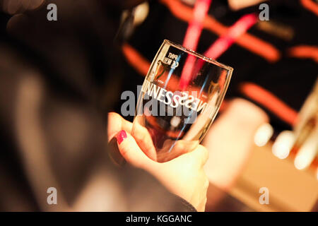 Close-up di femmine della mano che tiene vuoto birra Guinness bicchiere Foto Stock