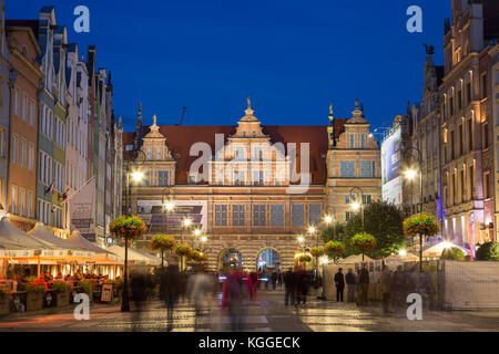 Vista di persone, ristoranti, cancello verde e altri vecchi edifici al mercato lungo, fine del Long Lane, nelle principali città (città vecchia) in Gdansk, al tramonto. Foto Stock