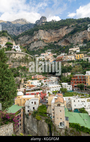 Case colorate e le imprese si aggrappano alle scogliere di Positano, Italia. Una popolare destinazione turistica lungo la famosa Costiera Amalfitana road. Foto Stock