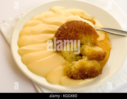 Deliziosi piatti tradizionali dessert invernale, melassa appiccicosa pudding con crema pasticcera Foto Stock