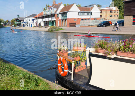 Casa galleggiante e studenti che vogano sul fiume Cam di fronte al Goldie Boathouse CUBC, club di canottaggio vicino a Midsummer Common, Cambridge, Inghilterra, Regno Unito Foto Stock