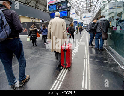 Parigi, Francia. Uomo con una valigia su ruote in Gare de l'Est Foto Stock