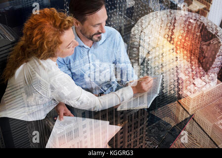 Piacevole donna suggerendo correzioni nel suo colleghi note Foto Stock