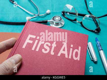 Medico detiene il libro sulla medicina di primo soccorso in un ospedale Foto Stock