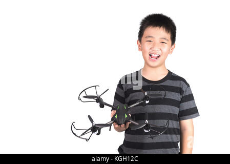 Ragazzo asiatico che tiene il drone o il quadricottero in mano, studio girato isolato su sfondo bianco. Foto Stock