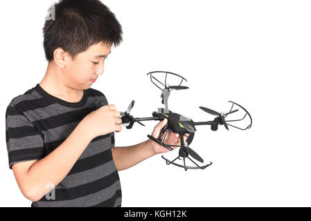 Ragazzo asiatico che tiene il drone o il quadricottero in mano, studio girato isolato su sfondo bianco. Foto Stock