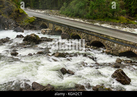 Un antico ponte in pietra. strada che attraversa il fiume. latefoss, Norvegia Foto Stock