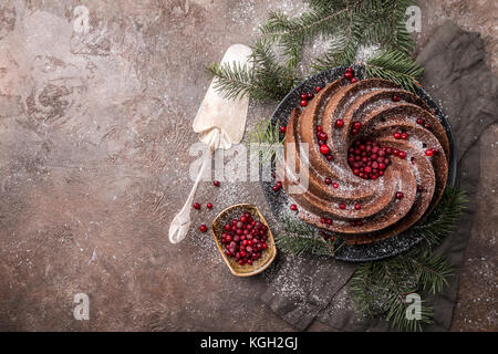 Gingerbread bundt cake per natale con lingonberry e decorazioni di Natale su sfondo scuro, vista dall'alto Foto Stock