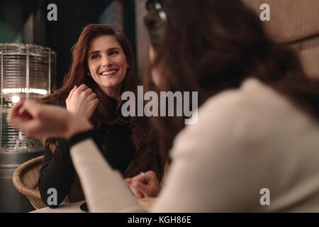 Due amiche parlando a un coffee shop. Giovani donne seduto in un bar. Foto Stock