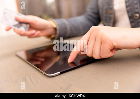 Donna shopping utilizzando un tablet PC e una carta di credito . piscina.close-up Foto Stock