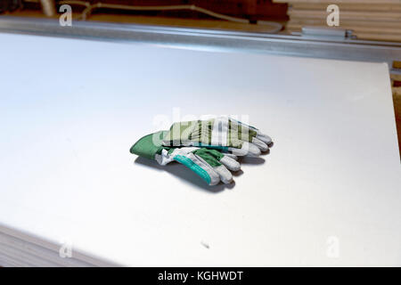 Attico ristrutturazione. costruire guanti giacciono sulla pila di muro a secco Foto Stock