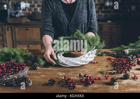 Fioraio rendendo ghirlanda di Natale Foto Stock