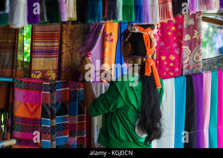 CHIANG RAI, Tailandia - 4 Novembre 2017: Unidentified lungo collo Karen hill tribe donna vendita di arte popolare merci Foto Stock