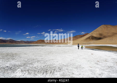 Madre e figlio camminare sul sale rive del lago di montagna Tso Kar in Himalaya, Ladakh, Jammu e Kashmir in India. Foto Stock