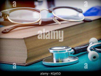 Libri di medicina accanto a uno stetoscopio e bicchieri, immagine concettuale Foto Stock