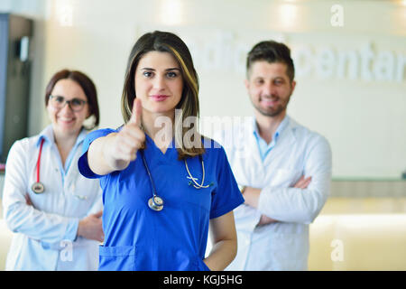 Giovane femmina attraente medico nella parte anteriore del gruppo di medici. Foto Stock