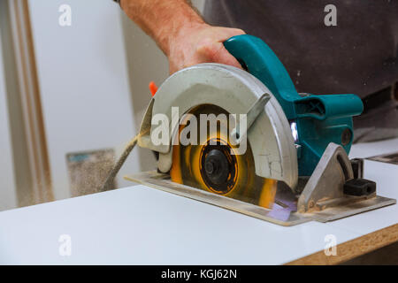 Operaio edile mediante il cursore composto sega o sega circolare per il taglio di legno massiccio bordo. Dettagli di costruzione, lavori di ristrutturazione Foto Stock