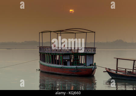 Una barca è galleggiante sul fiume Gange al momento del sorgere del sole in varanasi,l'india. Foto Stock