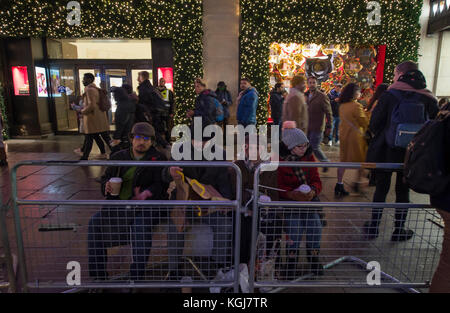 Il West End, Londra, Regno Unito. 7 Nov 2017. I negozi del West End di Londra si accergono per la stagione natalizia di notte le luci di Oxford Street si accendono. Un gruppo di acquirenti attende la cerimonia di accensione fuori Selfridges in Oxford Street. Credit: Malcolm Park/Alamy Live News. Foto Stock