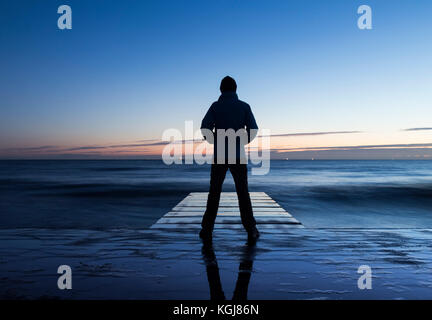 Billingham, Inghilterra nord-orientale. 8 Nov 2017. Tempo nel Regno Unito: Un camminatore si affaccia sul Nord in luce prima dell'alba a Seaton Carew su un mercoledì limpido e ghiacciato sulla costa nord-orientale. Credit: ALAN DAWSON/Alamy Live News Foto Stock