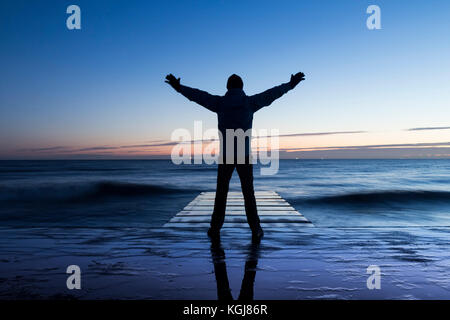 Billingham, Inghilterra nord-orientale. 8 Nov 2017. Tempo nel Regno Unito: Un camminatore si affaccia sul Nord in luce prima dell'alba a Seaton Carew su un mercoledì limpido e ghiacciato sulla costa nord-orientale. Credit: ALAN DAWSON/Alamy Live News Foto Stock