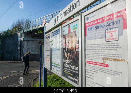 Manchester, Regno Unito. 08 Nov, 2017. Un pedone attraversa la strada in condizioni di intensa luce invernale segnaletica in passato a Mauldeth Road Stazione Ferroviaria, Burnage, Manchester. Il digital signage fornisce informazioni sull'utilizzo delle ferrovie mercoledì 8 novembre a causa dell'azione industriale da membri della RMT Unione. Credito: Matthew Wilkinson/Alamy Live News Foto Stock