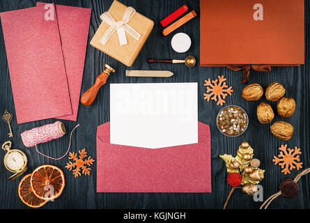 Il modello sul tema della festa di Natale la corrispondenza. busta aperta con un foglio di carta e forniture postali e le decorazioni di Natale. top view wi Foto Stock