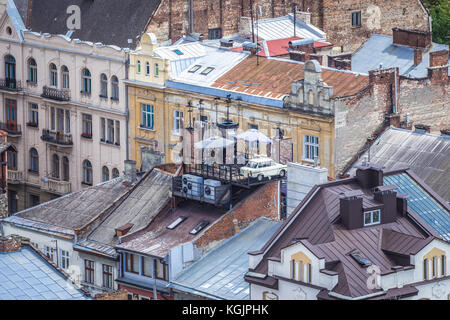 Trabant auto sul tetto del famoso ristorante Casa delle leggende sulla città vecchia di Lviv in Ucraina. Vista dalla torre del Municipio Foto Stock