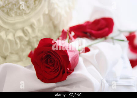 Una rosa rossa e una fetta di torta, un matrimonio o un concetto di san valentino Foto Stock