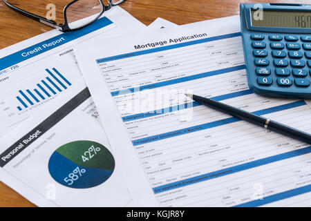 Domanda di credito ipotecario sulla scrivania con rapporto di credito, budget, calcolatrice, penna e occhiali di protezione Foto Stock