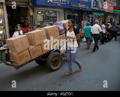 Il Pettah Colombo Sri Lanka primo Cross Street uomo tirando il carrello consegna delle merci Foto Stock