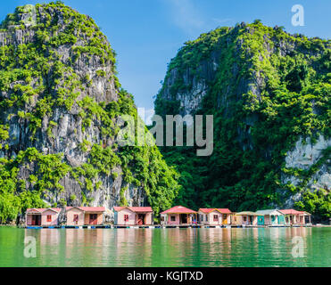 Flottante il villaggio di pesca con l'isola di roccia in background e la baia di Ha Long, Vietnam Foto Stock