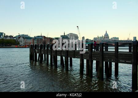 Vista sul Tamigi al crepuscolo attraverso jetty da Southbank a St Pauls con lo skyline di Londra Foto Stock