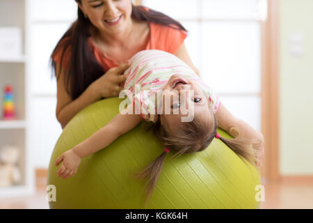 Bambino Cute girl stretching sul fitness pilates palla con la madre in palestra Foto Stock