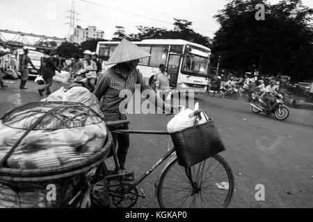 La scena da fuori la grande mattina vegetale frutta/mercato all'ingrosso a lunga Bien ponte nel centro di Hanoi, Vietnam. Le biciclette sono caricate al massimo. Foto Stock