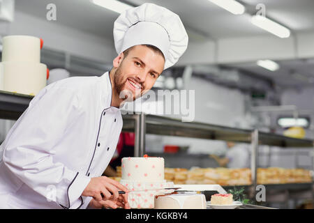 Lo chef pasticceria uomo facendo la torta in cucina Foto Stock