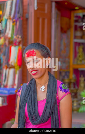 Kathmandu, Nepal ottobre 15, 2017: ritratto di donna in abito tradizionale rosso con pezzi di riso nella sua fronte, a Kathmandu, Nepal in uno sfondo sfocato Foto Stock