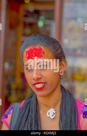 Kathmandu, Nepal ottobre 15, 2017: ritratto di donna in abito tradizionale rosso con pezzi di riso nella sua fronte, a Kathmandu, Nepal in uno sfondo sfocato Foto Stock