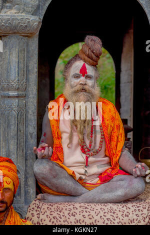 KATHMANDU, NEPAL - 22 MARZO 2017: Primo piano di Yogi Shaiva sadhu seduto nel Tempio Pashupatinath di Kathmandu con le gambe incrociate, in Nepal Foto Stock