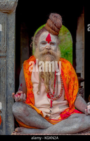KATHMANDU, NEPAL - 22 MARZO 2017: Primo piano di Yogi Shaiva sadhu seduto nel Tempio Pashupatinath di Kathmandu con le gambe incrociate, in Nepal Foto Stock