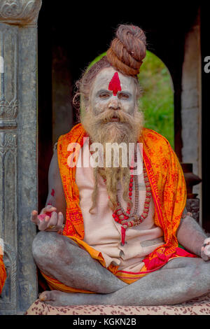 KATHMANDU, NEPAL - 22 MARZO 2017: Primo piano di Yogi Shaiva sadhu seduto nel Tempio Pashupatinath di Kathmandu con le gambe incrociate, in Nepal Foto Stock
