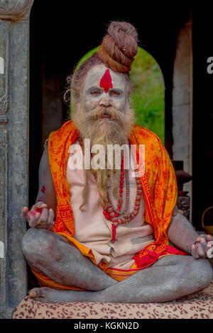KATHMANDU, NEPAL - 22 MARZO 2017: Primo piano di Yogi Shaiva sadhu seduto nel Tempio Pashupatinath di Kathmandu con le gambe incrociate, in Nepal Foto Stock