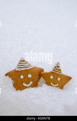 Due natale gingerbread stelle nel bianco della neve Foto Stock