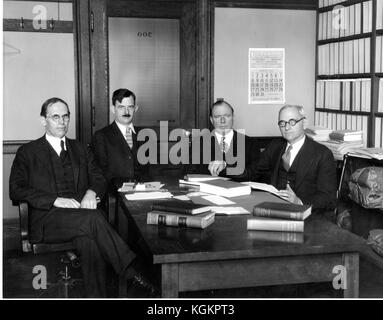 Fotografia di gruppo dei professori di legge di Johns Hopkins Walter Cook, Hessel Yntema, Leon Marshall e Herman Oliphant seduti intorno a un tavolo con libri aperti all'interno dell'ufficio di Cook, marzo 1931. Foto Stock