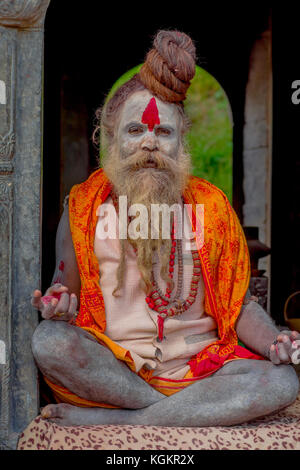 KATHMANDU, NEPAL - 22 MARZO 2017: Primo piano di Yogi Shaiva sadhu seduto nel Tempio Pashupatinath di Kathmandu con le gambe incrociate, in Nepal Foto Stock