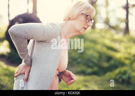 Infelice di età della donna che soffre di dolori acuti Foto Stock