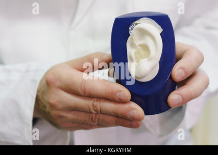 Sezione mediana del medico azienda modello anatomico con apparecchi acustici in ufficio Foto Stock