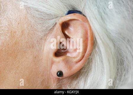 Close-up di donna con i capelli grigi che indossa Hearing Aid Foto Stock