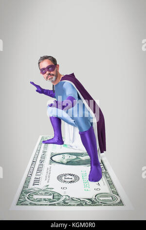 Il supereroe che la piegatura con le braccia aperte e gambe divaricate su American artificiale di un dollaro Foto Stock