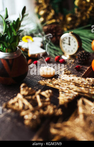 Sfondo di natale con decorazioni e candele, candela sul fuoco con la mano della donna Foto Stock